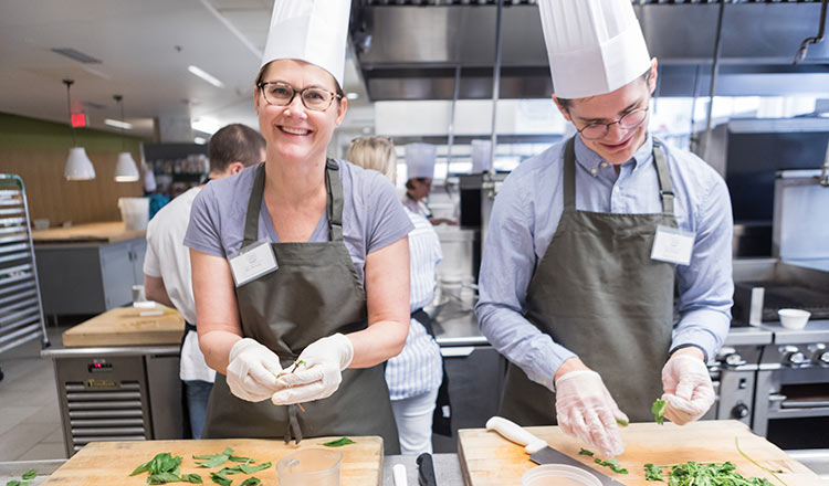 A man and woman taking a cooking class.