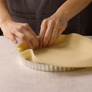Lining a metal tart pan with pie dough
