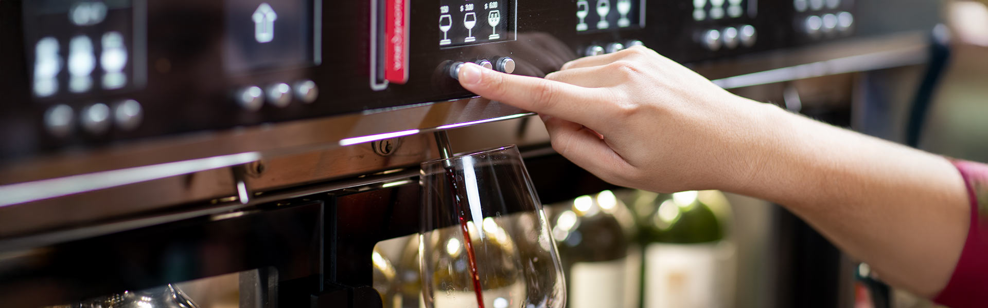 Guests pour wine from a self-serve station at a sleek, modern bar at CIA at Copia in Napa, CA.