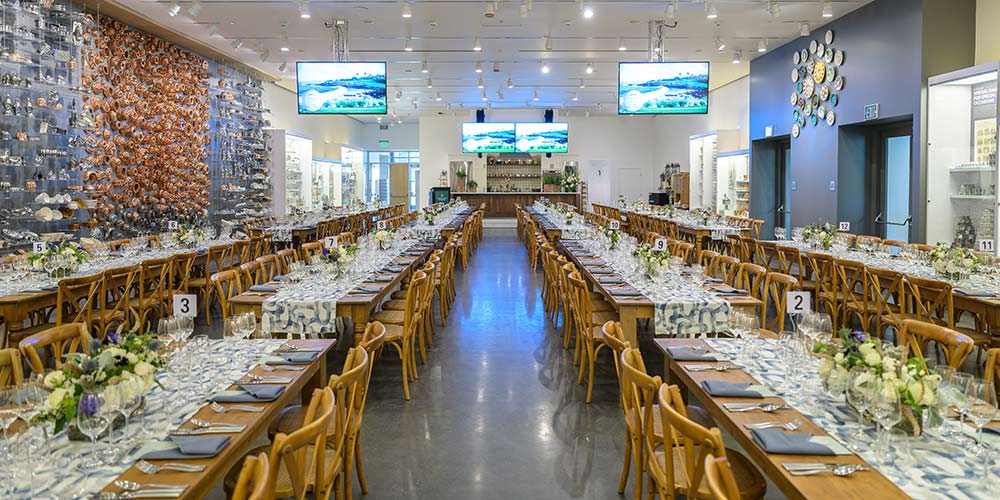 Long tables with blue runners and flowers at a private dining event at CIA at Copia in Napa, CA.