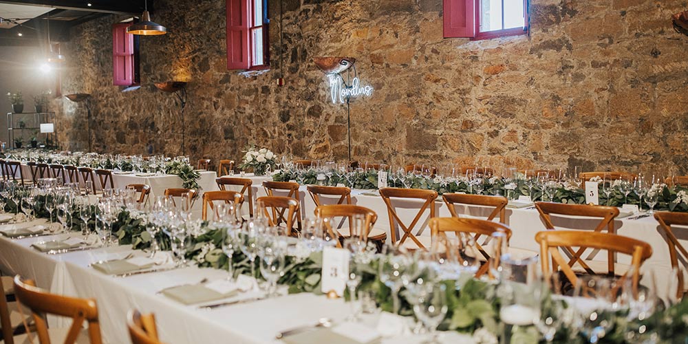 CIA at Greystone's Barrel Room set up for private dining with long tables, wine glasses, and wooden chairs.